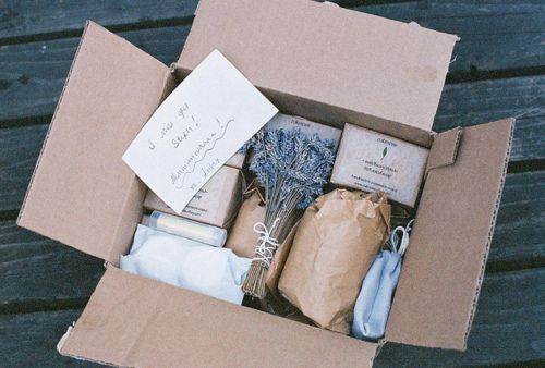 an open cardboard box filled with items on top of a wooden table