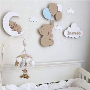 a baby crib with teddy bears hanging on the wall