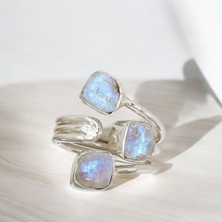 Raw Rainbow Moonstone & Blue Fire Moonstone Ring - Handmade Silver Adjustable Ring Description: Discover the enchanting beauty of our handcrafted silver ring, featuring both Raw Rainbow Moonstone and Blue Fire Moonstone. This unique triology design combines the mystical allure of moonstones with the elegance of fine silver, creating a piece that's as captivating as it is versatile. Features:     Materials: Genuine Raw Rainbow Moonstone, Blue Fire Moonstone, and sterling silver.     Design: Adjus Stackable Moonstone Jewelry Gift, Fusion Style Moonstone Ring Gift, Fusion Style Moonstone Gemstone Jewelry, Silver Stackable Gemstones As A Gift, Silver Stackable Gemstones For Gift, Adjustable Stackable Moonstone Jewelry, Fusion Style Moonstone Jewelry For Anniversary, Silver Crystal Ring With Birthstone For Healing, Spiritual Stackable Moonstone Jewelry