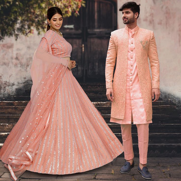 Menswear:- Faux Georgette Sherwani in Peach. This Readymade attire with Satin Lining is Enhanced With Fancy Buttons, Pockets, Stone Studded Brooch, Resham and Sequins Work. Crafted in Chinese Collar Neck and Full Sleeve Available with an Art Silk Pant in Peach and an Art Silk Inner Front Open Kurta in Peach Do note: Footwear shown in the image is for presentation purposes only. Half to one inch may vary in measurement. (Slight variation in actual color vs. image is possible) Lehenga Choli:- Faux Bandhgala With Resham Embroidery For Reception Navratri, Resham Embroidered Bandhgala For Reception Navratri, Reception Sherwani With Chikankari Embroidery For Navratri, Embroidered Bandhgala For Navratri Reception, Festive Pink Sherwani With Dabka Work, Embroidered Bandhgala For Reception And Navratri, Pink Sherwani With Dabka Work, Fitted Pink Sherwani With Dabka Work, Pink Fitted Sherwani With Dabka Work