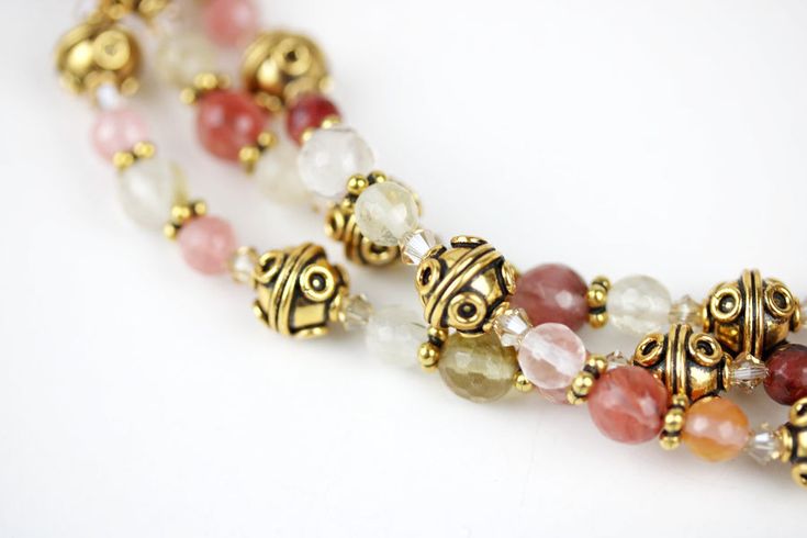 Style and luxury are embodied in this lovely and fashionable three strand round cherry quartz beads necklace. Gold Bali bead and rondelles, with Swarovski© crystals are adorned with an adjustable gold chain and lobster claw claspLet loose in the... Elegant Double Strand Beaded Necklace With Natural Stones, Elegant Adjustable Beaded Necklaces With Spacer Beads, Elegant Multi-strand Beaded Crystal Necklace, Elegant Multi-strand Gemstone Beaded Necklaces, Elegant Multi-strand Beaded Crystal Necklaces, Elegant Handmade Double Strand Crystal Necklaces, Elegant Beaded Multi-strand Crystal Necklaces, Elegant Beaded Multi-strand Crystal Necklace, Elegant Handmade Double Strand Crystal Necklace