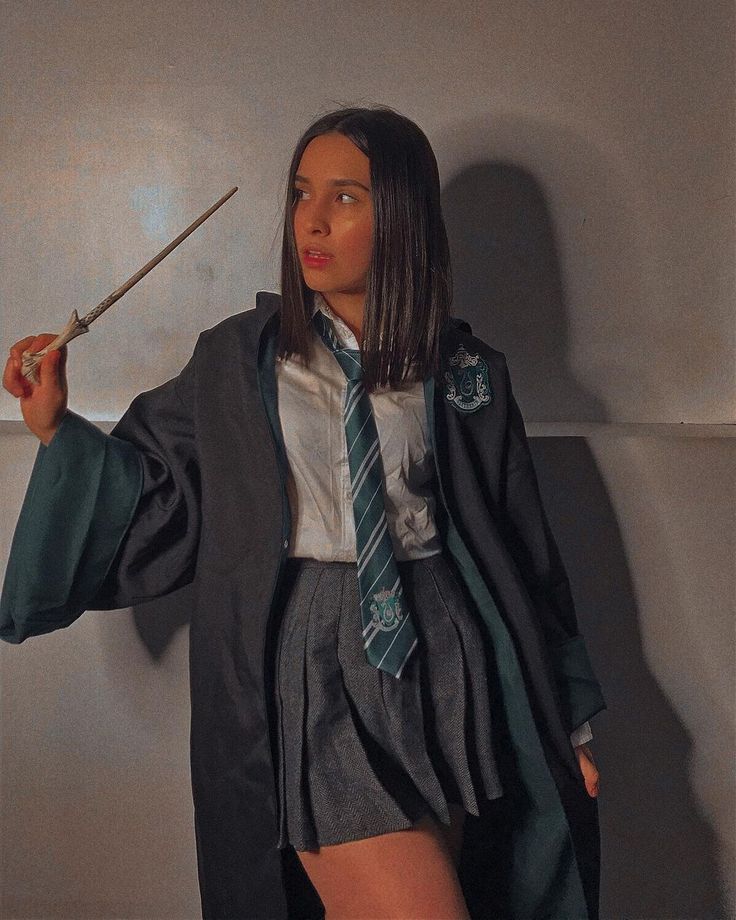 a woman dressed as harry potter holding a wand