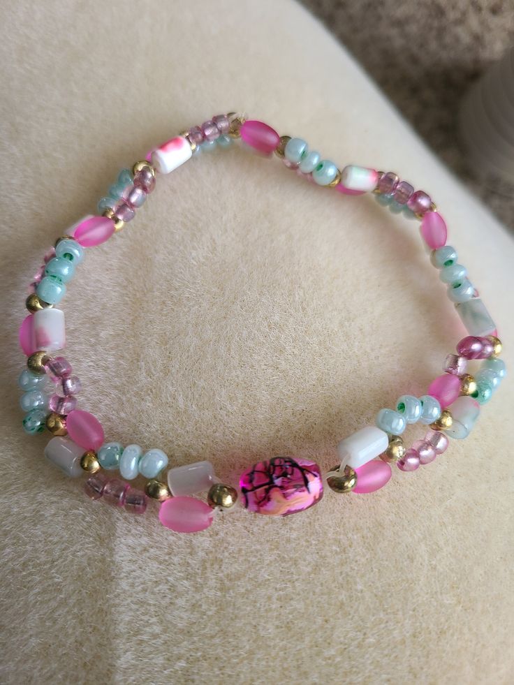 This bracelet is made with plastic beads. The pink and mint green beads are strung on a stretch cord. This bracelet will fit an 8 inch wrist. Green And Pink Bracelet, Pink Stretch Bracelet With Round Beads For Friendship, Pink Stretch Bracelet With Colorful Beads For Friendship, Pink Stretch Bracelet With Spacer Beads, Pink Stretch Bracelet With Spacer Beads For Friendship, Pink And Mint, Green Bracelet, Green Beads, Plastic Beads