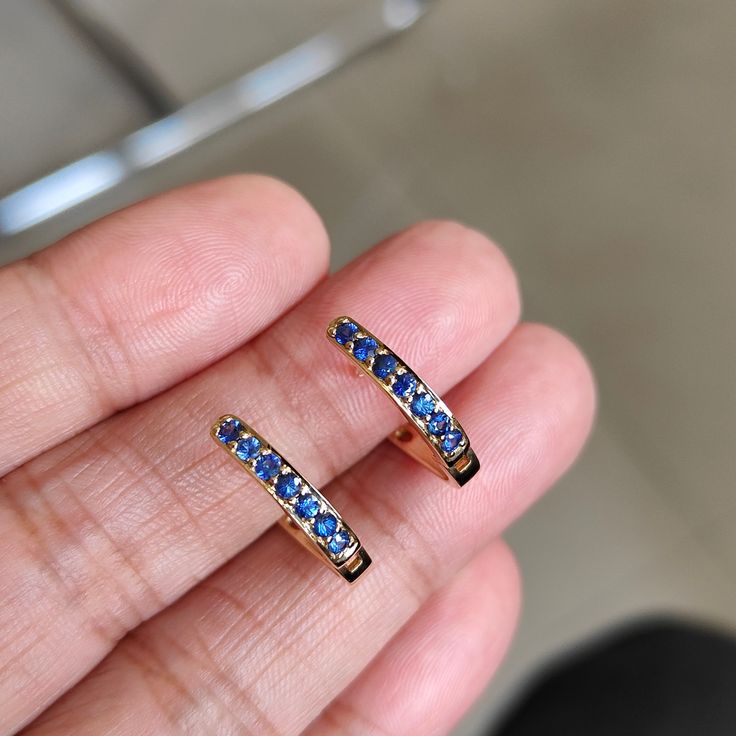 This stunning Earrings is set in 14k Solid Yellow Gold with Natural Blue Sapphire with utmost precision. It is a unique gemstone Drill Earrings for nearly every occasion and is completely hassle-free jewelry. ITEM DETAILS: *  GEM: Blue Sapphire * GEM SIZE: 2mm * GEM SHAPE: Round * Gem weight: 1.62 carats * Gold Purity: 14KT (58.33% approx.) * Gold Weight: 2.15 gram * Total Weight of the Earrings: 2.48 gram The Gold purity is guaranteed and it comes with authentic 14KT gold hallmark. Since my ite Blue Hoop Earrings With Prong Setting For Anniversary, Blue Hoop Earrings With Prong Setting, Blue Round Hoop Earrings For Anniversary, Blue Hoop Huggie Earrings Gift, Blue Huggie Single Earring, Blue Huggie Hoop Earrings For Gift, Blue Huggie Hoop Earrings As Gift, Blue Huggie Hoop Earrings For Pierced Ears, Sapphire Hoop Earrings For Anniversary Fine Jewelry