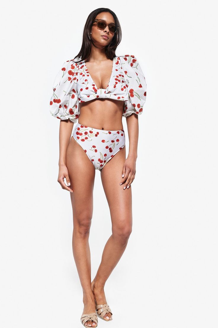 This item is final sale. Iconic and irreverent, AD's swimwear pieces are versatile and dynamic to be worn between the beach and the city. This Cherry Bomb print swimsuit can be worn with a pareo skirt for lunch by the pool. Combine with the skirt of the same print and low-heeled sandals and you will have a new look for evening drinks! Model is wearing a size small This item runs true to size Composition85% POLYAMIDE 15% SPANDEX Chic Printed Swimwear For Vacation, Chic Printed Swimwear For Poolside, Chic Printed Swimwear For Pool, Fitted Short Sleeve Swimwear For Beach Party, Trendy Short Sleeve Swimwear For Spring, Trendy Short Sleeve Swimwear For The Beach, Trendy Short Sleeve Swimwear For Beach, Printed White Swimwear For Brunch, White Printed Swimwear For Resort Season