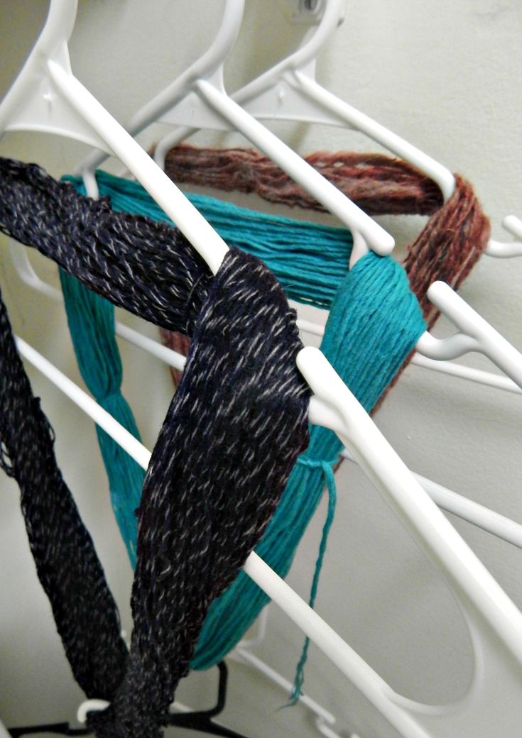 there are several pieces of yarn on the rack