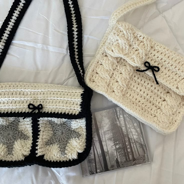 two crocheted purses sitting on top of a white bed next to each other