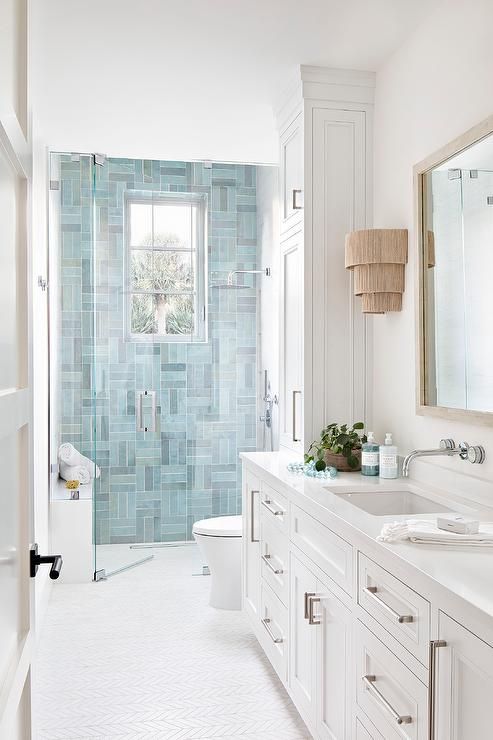 a white bathroom with two sinks and a large mirror on the wall next to it