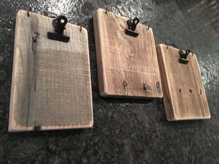 three pieces of wood sitting on top of a black floor next to each other with clips in them