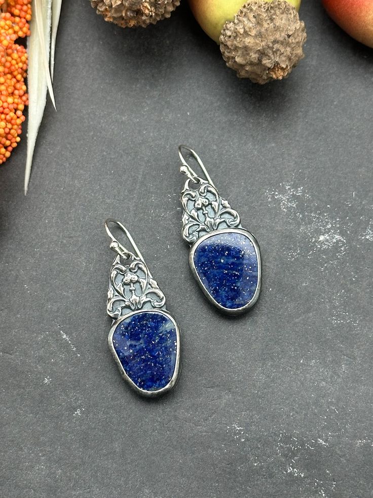 "These earrings are a statement piece to add to your collection.   Gorgeous high quality Lapis Lazuli set in fine silver with sterling silver filigree details. They have been suspended from sterling silver French hooks.  Earring Measurements: 1 1/2\" long by 5/8\" wide" Unique Sterling Silver Earrings With Intricate Design, Blue Sterling Silver Pendant Earrings, Blue Pendant Sterling Silver Earrings, Artisan Sterling Silver Earrings With Intricate Design, Sterling Silver Pendant Earrings With Intricate Design, Blue Sterling Silver Earrings With Intricate Design, Sterling Silver Blue Earrings With Intricate Design, Unique Sterling Silver Filigree Earrings, Ornate Sterling Silver Pendant Earrings