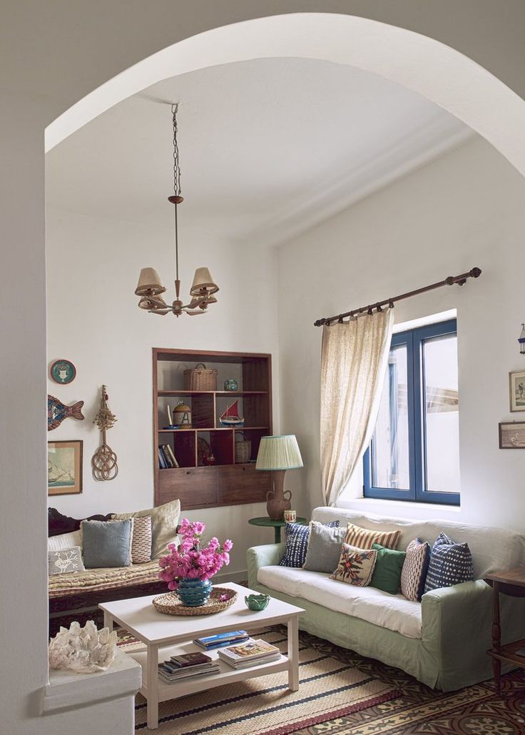 a living room filled with furniture and a large window next to a rug on the floor