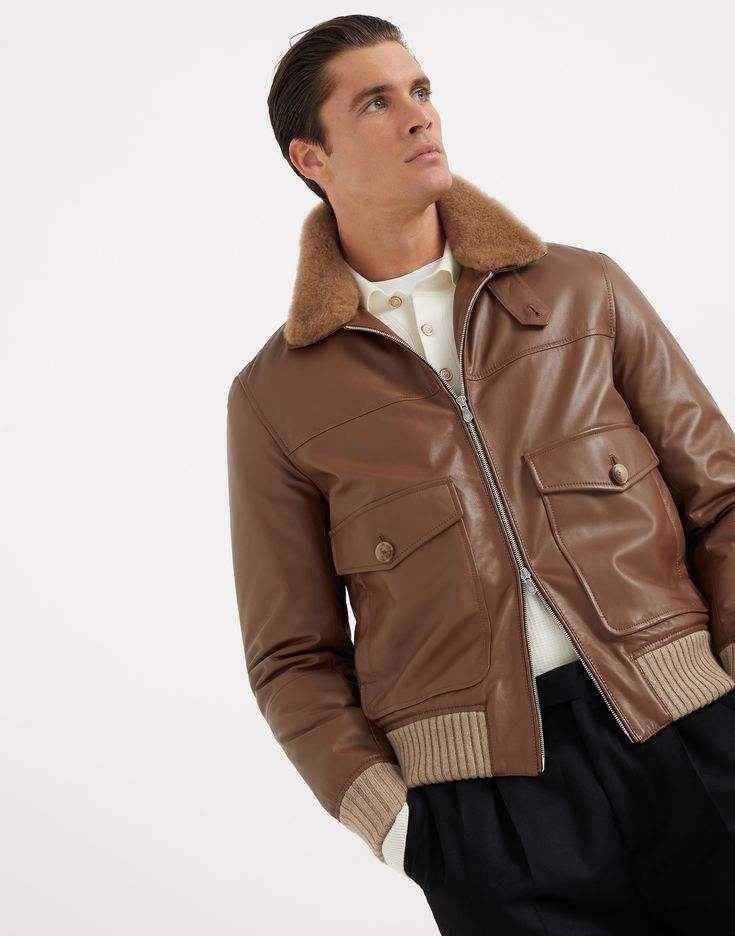 Polished calfskin aviator jacket with Thermore® padding and detchable shearling collar Refined Brunello Cucinelli materials and finishes enrich the beauty of this classic padded aviator jacket. The natural sheen of polished calfskin is paired with a soft, removable shearling collar and knit trim, creating a balanced mix of textures. The Thermore® padding ensures warmth and cozy comfort. Luxury Leather Jacket With Flap Pockets, Luxury Shearling Leather Jacket For Work, Luxury Shearling Outerwear With Padded Collar, Luxury Winter Outerwear With Contrast Collar, Leather Jacket With Padded Lapel Collar For Work, Workwear Leather Jacket With Padded Lapel Collar, Fitted Shearling Outerwear With Padded Collar, Winter Aviator Leather Jacket With Padded Collar, Luxury Biker Jacket With Faux Fur Lining