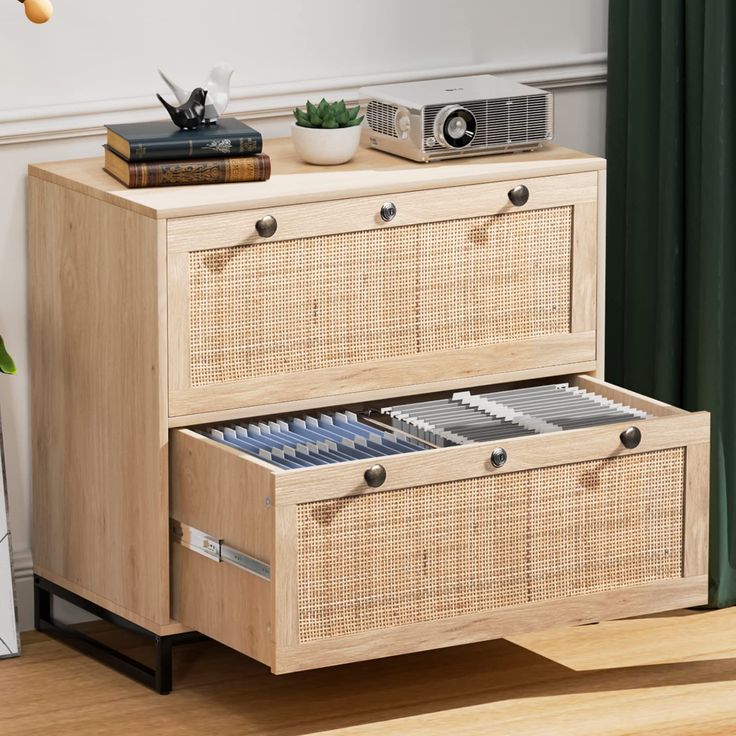 a wooden cabinet with two drawers and an old camera on the top shelf next to it