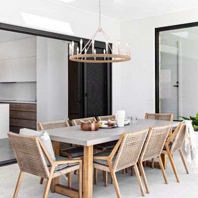 a dining room table with chairs and a chandelier hanging from it's ceiling