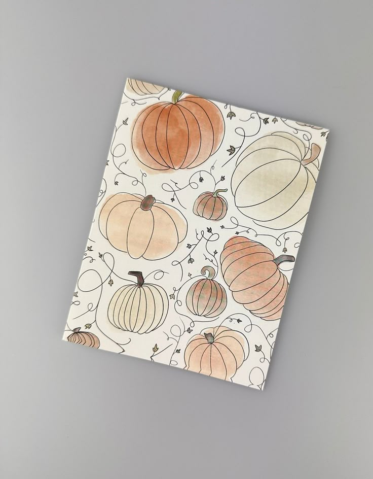 an orange and white paper with pumpkins printed on the front, sitting on a gray surface