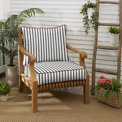 a wooden chair sitting on top of a rug next to a potted plant and ladder