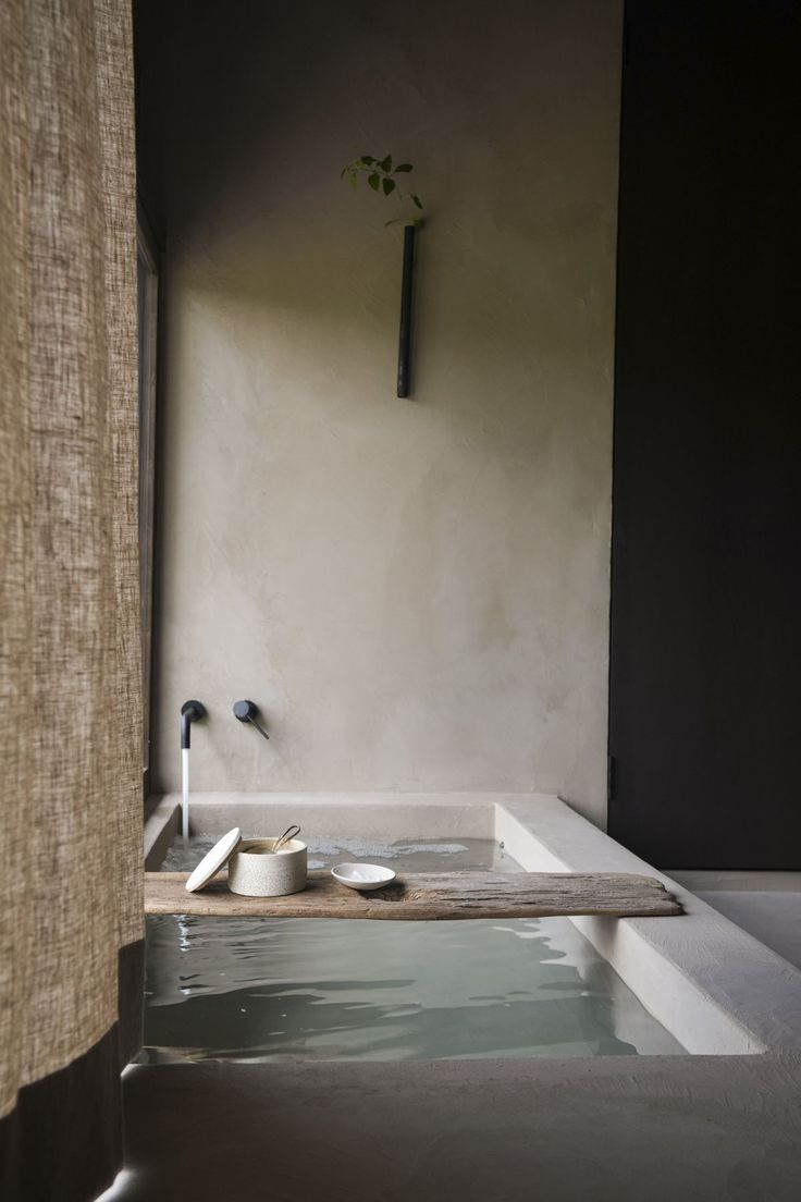 a bathroom with a sink, toilet and bathtub that is made out of concrete