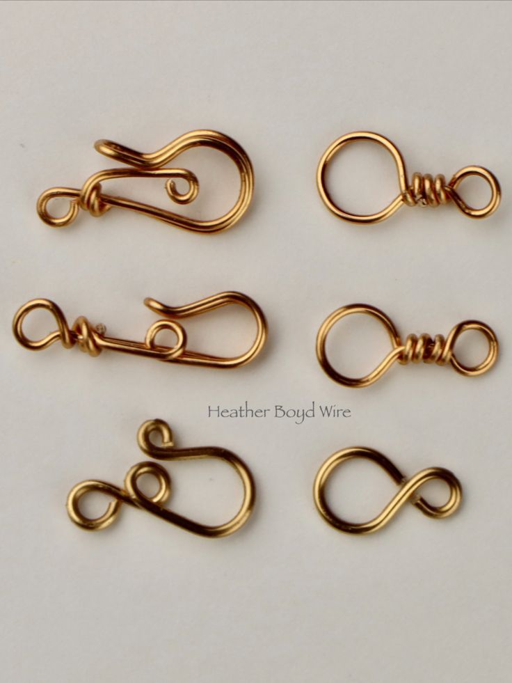 four pairs of gold plated metal wire with loop ends on white background, closeup