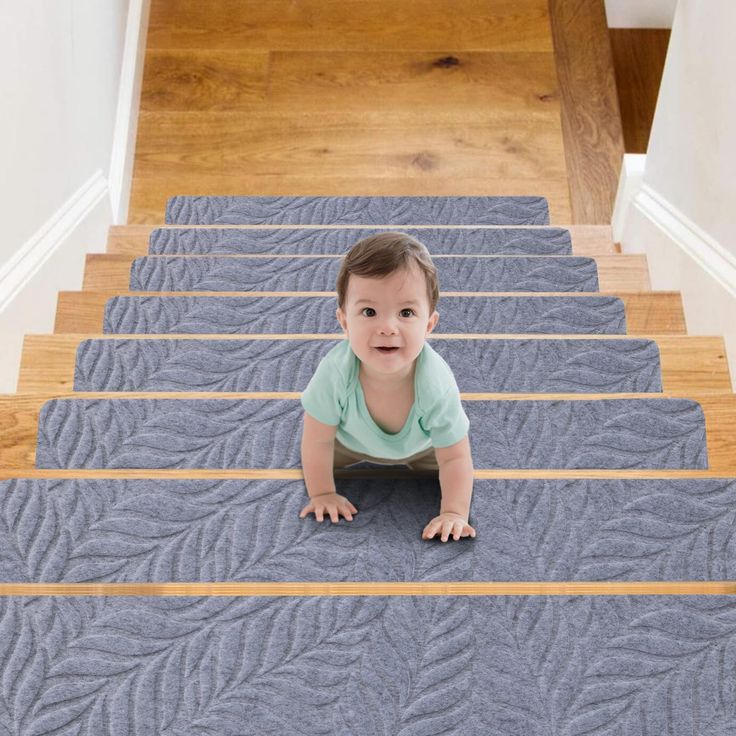 a baby is sitting on the stairs in front of some carpeted stair treads