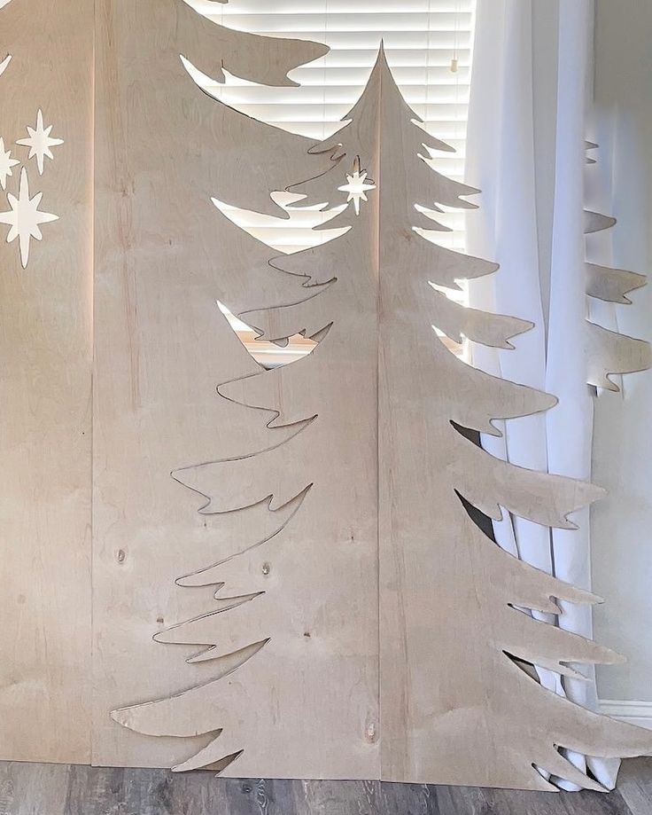 a christmas tree made out of plywood with white snowflakes