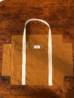 a brown and white bag sitting on top of a wooden table next to a pair of scissors