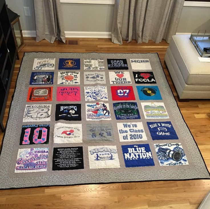 a living room area with a large rug covered in t - shirts