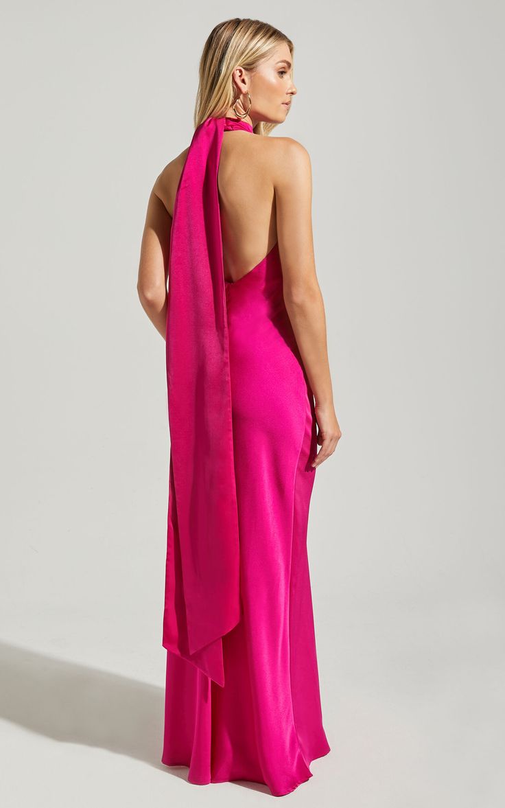 the back of a woman in a pink dress with a large shawl draped over her shoulders