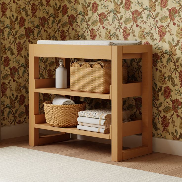 a wooden shelf with baskets and towels on it next to a wallpapered wall