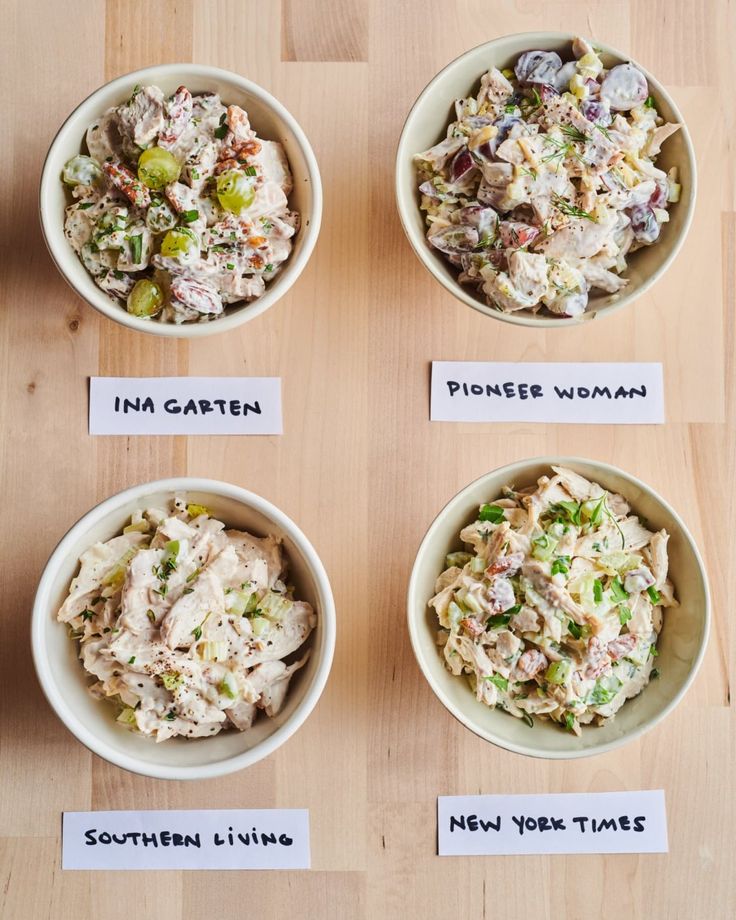 four bowls with different types of food in them sitting on a table next to each other