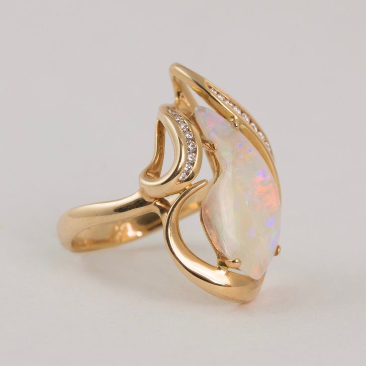 Abstract Opal Ring – Jewels by Lubeck Luxury Yellow Gold Opal Ring With Accent Stones, Luxury Opal Ring With Accent Stones For Formal Occasions, Luxury Yellow Gold Opal Ring With Halo Setting, Modern Marquise Cut Gemstone Rings, Modern Topaz Ring With Brilliant Cut For Formal Occasions, Formal Pear-shaped Topaz Ring Fine Jewelry, Luxury Yellow Gold Opal Ring With Brilliant Cut, Luxury Brilliant Cut Bypass Ring For Formal Occasions, Luxury Bypass Ring With Brilliant Cut For Formal Occasions