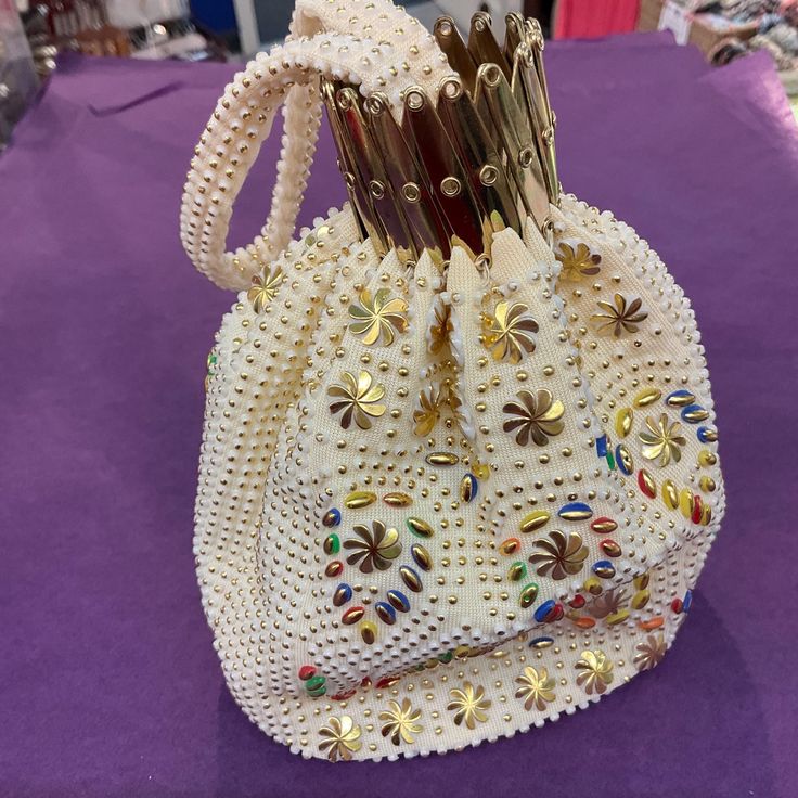 Sparkle and shine at any event with this fabulous mid century cocktail bag. Made from rich cream fabric, It is beautifully decorated all over with bonded floral, circular and oval iridescent gold rainbow beads. It has an unusual gold tone metal concertina opening and a beaded short strap, and is lined in cream satin. Measures 5"x 7" x 2.25" at the base and sides. Excellent vintage condition, a groovy bag that is surely ready to hit the dance floor once more! Rainbow Beads, Ladies Day, Clutch Handbag, Gold Tone Metal, Formal Event, Evening Bags, Purses And Handbags, Paisley, Birthday Gifts