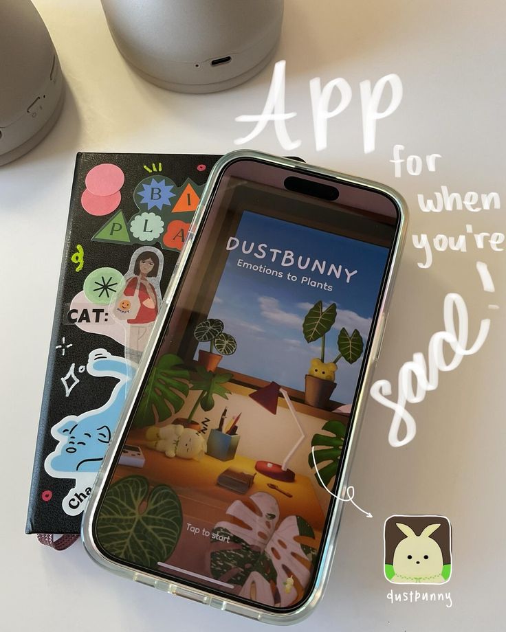 an iphone with stickers on it sitting next to a mouse and other items that include the phone