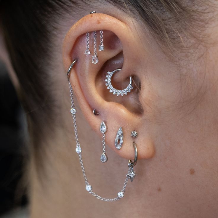 a woman with ear piercings and chains on her ears