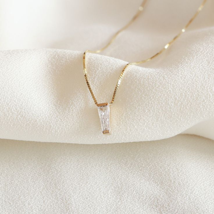 Indulge in timeless elegance with our Baguette Diamond Necklace, a captivating piece in 14k gold. The tapered baguette diamonds are delicately set in a bezel, creating a floating effect that adds a touch of sophistication to your look. This dainty necklace, with its minimalist design, is perfect for everyday wear. Elevate your style with the understated beauty of our Baguette Diamond Necklace, a must-have addition to your collection of necklaces for women. Measurements: * Gem Stones: 100% Natura Baguette Diamond Necklace, Floating Diamond Necklace, Baguette Necklace, Bezel Necklace, Baguette Diamonds, Solitaire Pendant, Gem Stones, Necklace Dainty, Necklaces For Women