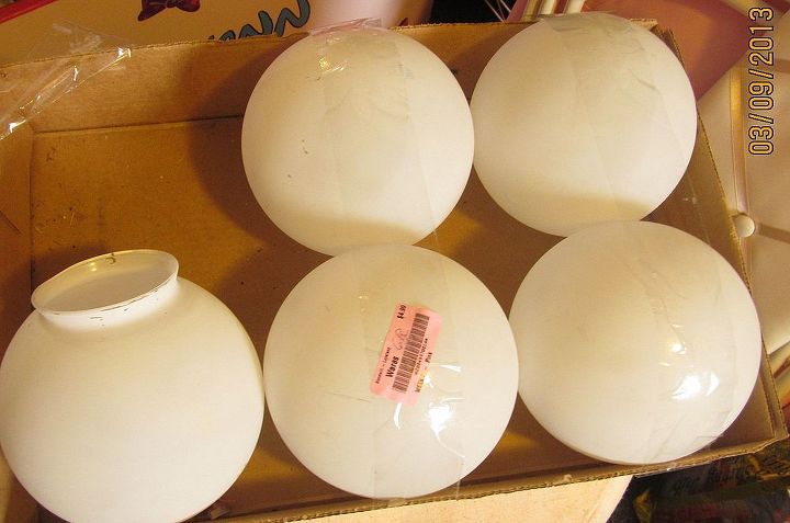 four white vases sitting on top of a cardboard box