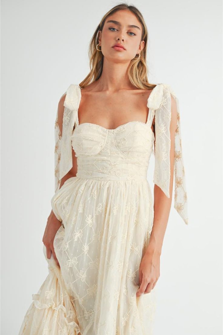 Get ready to turn heads with this charming Cream Sleeveless Bow Embroidered Ruched Bust Shoulder Tie Tiered Midi Dress. Its unique design features a ruched bust and shoulder ties, creating a sophisticated yet flirty look. The tiered skirt adds a touch of playful elegance, making it the perfect addition to your wardrobe. Bow embroidered detail Shoulder tie straps Ruched bra cup bust Fully lined Back smocked Back zipper closure Ruffle tiered Midi length Shoulder Strap Dress, Wedding Ready, Senior Picture Outfits, Bra Cup, Puff Sleeve Dress, School Dances, Tiered Midi Dress, Picture Outfits, Cute Fit