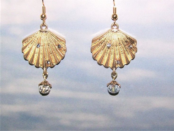 These are handcrafted gold color shell dangle pierced earrings made from novelty charms.  Each earring hangs about 1-3/4" long,  The gold color is not as dark as it comes through the pictures and they have sparkle gems that don't show well in the pictures.  The wire used is a gold color.   At this time I have to ship ONLY to U.S. addresses. Gold Shell-shaped Metal Earrings, Gold Shell-shaped Brass Earrings, Gold Brass Shell-shaped Earrings, Gold Brass Shell Earrings, Gold Shell-shaped Earrings With Ear Wire, Adjustable Gold Earrings With Dangling Charms, Gold Earrings With Dangling Charms, The Wire, Pierced Earrings