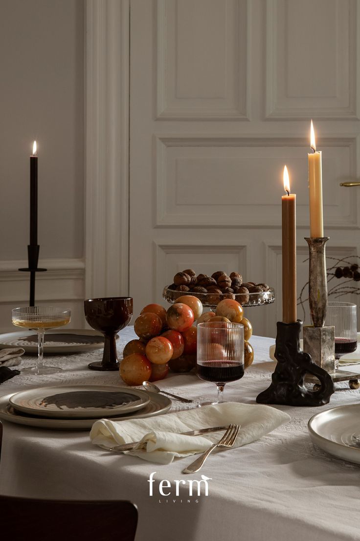 the table is set with plates, silverware and candles