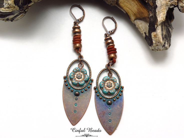 These captivating earrings showcase a unique blend of textures and colors, perfect for adding a touch of bohemian flair to your ensemble. The focal point is a stunning copper tribal pendant, adorned with a rich turquoise patina. Suspended within the pendant is a delicate Czech glass turquoise wild rose flower, adding a hint of romantic charm. The earrings are further enhanced by the addition of spacer beads and decorative leather barrel knots, lending a rustic and handcrafted feel. Choose from 4 different earwire options to find the perfect fit for your style. 𝐋𝐄𝐍𝐆𝐓𝐇: 3 1/2" with lever back earwires. Kidney wires will add about 1". 𝐖𝐈𝐃𝐓𝐇: 3/4" 𝐖𝐄𝐈𝐆𝐇𝐓: Each earring weighs 6.50 grams. A nickel weighs 5 grams. All jewelry is packaged ready for gift giving. Each item comes in Bohemian Wire Wrapped Bronze Earrings, Bohemian Bronze Wire Wrapped Earrings, Bronze Bohemian Wire Wrapped Earrings, Adjustable Bohemian Patina Earrings, Bohemian Blue Flower Earrings, Bohemian Copper Earrings With Patina, Bohemian Bronze Flower Earrings Nickel-free, Bohemian Bronze Flower Earrings Nickel Free, Bohemian Brass Dangle Flower Earrings