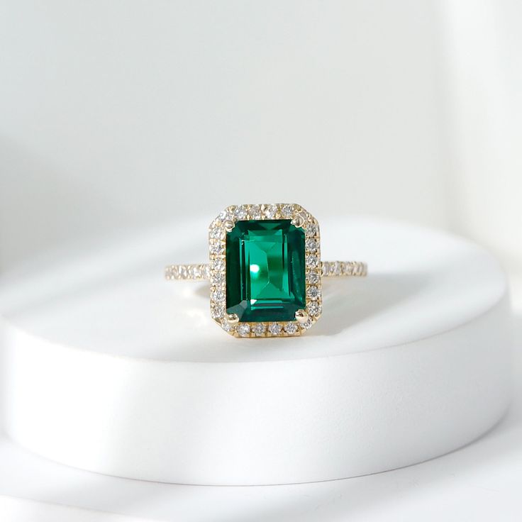 Product Details Add a touch of elegance and beauty to your look with this exquisite Created Emerald Engagement Ring. This simple yet stunning ring features a radiant Created Emerald that is sure to brighten up even the dullest of days. The Created Emerald is further enhanced by delicate Diamond, adding a touch of sparkle and glamour to the ring. Flaunt your style and sophistication with this remarkable Created Emerald Ring, and make a statement wherever you go. Product Information SKU SHP-RINGS112028732 Width 4 mm Height 11.5 mm Weight 2.14 gm (Approximate) LAB CREATED EMERALD INFORMATION No.of Stones 1 Pieces Total Weight 2.31 Carat (Approximate) Dimension(approx) Emerald Cut-7X9 mm-1 Pcs Color Green Cut Brilliant Shape Emerald Cut Setting Type Prong-Setting Quality Grade AAAA DIAMOND INF Emerald Ring With Diamond Halo, Emerald Cut Emerald Engagement Ring, Emerald Green Rings, Emerald Stone Engagement Ring, Emeralds Rings, Green Engagement Ring, Emerald Jewelry Ring, Engagement Rings Emerald, Emerald Halo Engagement Ring