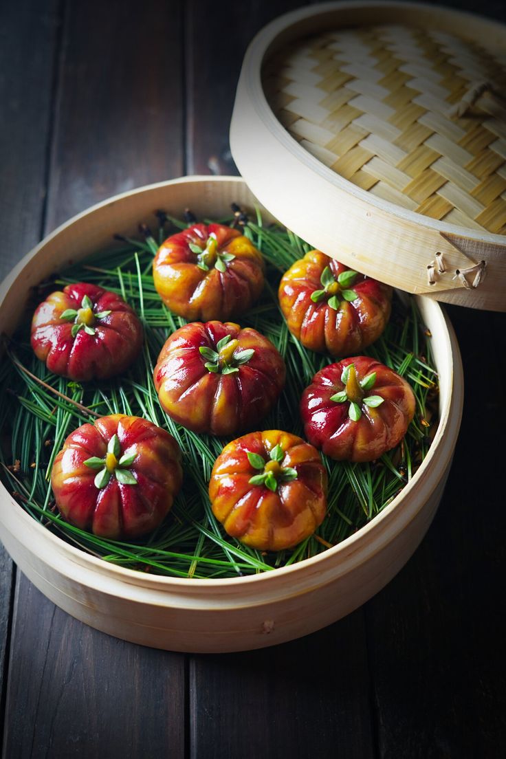 small tomatoes with green stems in a wooden bowl