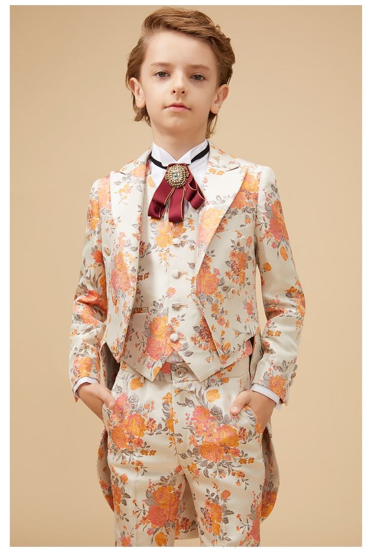 Traditional styling paired with modern chic. This 5-piece Floral Print Ensemble is both classical and flared with boulevardier adornments. Whether you find your family at a spring wedding reception or an exclusive summer banquet, your Petit Gentleman will be the center of attention. Our elegant Floral Print Ensemble comes with the Bouquet floral jacket, trousers, and matching vest, along with a brilliant white shirt that displays the signature royal red Victorian necktie. All 5 pieces are tailor Spring Formal Fitted Tuxedo, Spring Fitted Tuxedo For Formal Occasions, Elegant Spring Ceremony Suits, Elegant Fitted Spring Tuxedo, Spring Formal Fitted Three-piece Suit, Elegant White Summer Sets, Elegant White Three-piece Wedding Suit, Fitted Suits For Spring Formal, Fitted Suits For Spring Formal Occasions