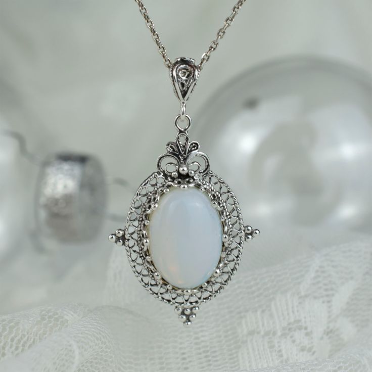 Moonstone Pendant Necklace For Formal Occasions, Sterling Silver Jewelry With Oval Cabochon, Oval Cabochon Moonstone Jewelry, White Oval Pendant Jewelry With Adjustable Chain, Elegant Opal Necklace With Large Pendant, Oval Cabochon White Gold Jewelry, White Sterling Silver Oval Cabochon Jewelry, Anniversary White Gold Cabochon Necklace, Silver Opal Necklace For Gift