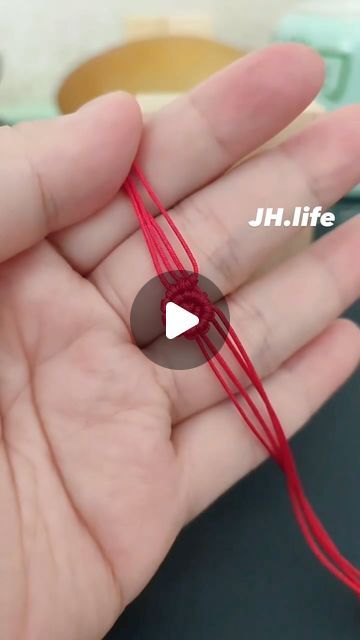 a person is holding some red string in their hand with the word jh life written on it