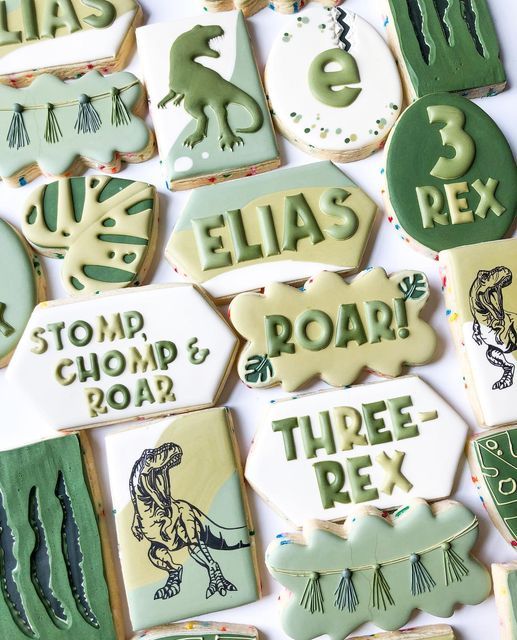 decorated cookies with green and white frosting are arranged on a table together in the shape of letters