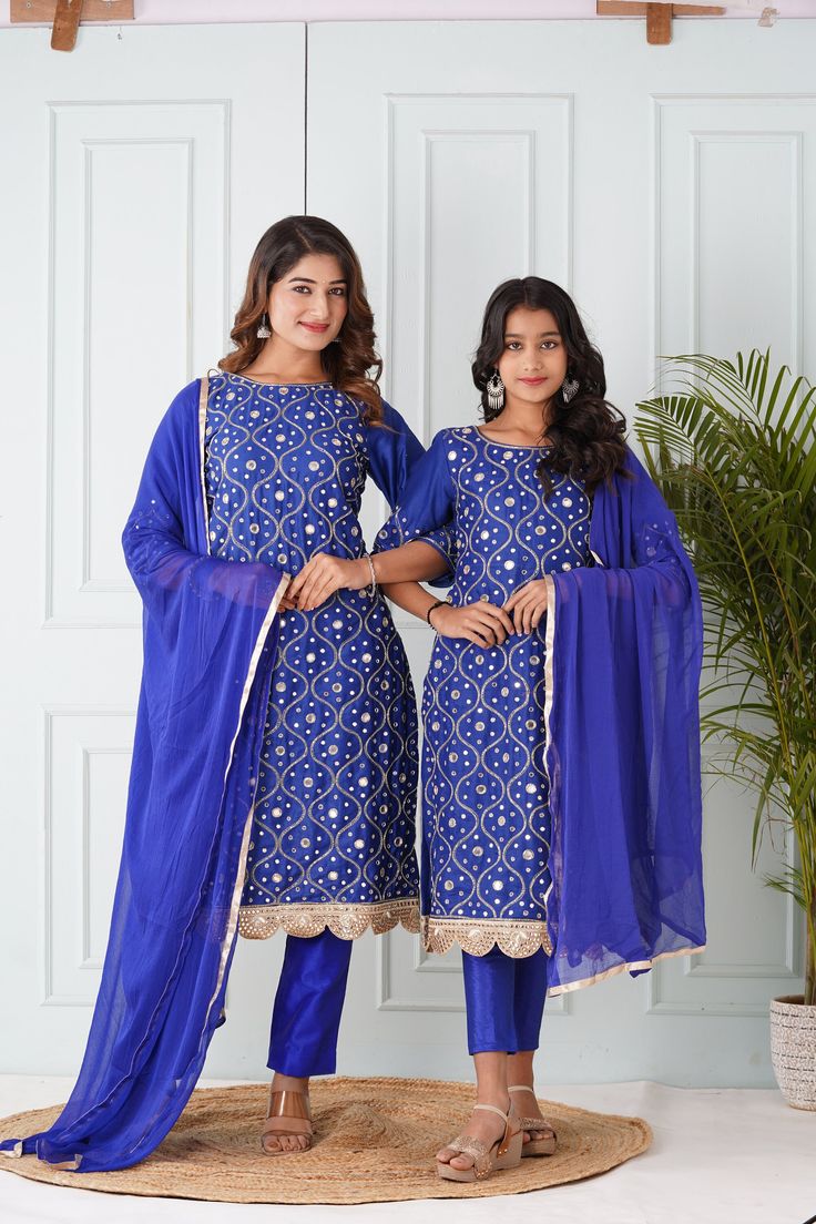 Mother's Salwar Kameez:-Cotton Silk Pakistani Suit in Royal Blue This Readymade Hand Embroidered attire with Cotton Lining is Enhanced with Pocket, Tassels, All Over Mirror, Zari, Cutbeads work along With Fancy Mirror Scalloped Border. Crafted in Round Neck and Quarter Sleeve. Available with an Art Silk Pant with Cotton Lining in Royal Blue and a Gota Lace Work Faux Chiffon Dupatta in Royal Blue. The Kameez and Bottom Lengths are 43 and 36 inches respectively Do note: Accessories shown in the im Semi-stitched Sets With Mirror Work Straight Kurta, Semi-stitched Sets With Mirror Work On Straight Kurta, Blue Bollywood Straight Kurta Set, Fitted Blue Traditional Wear For Diwali, Royal Blue Sets For Diwali Party, Blue Palazzo Set With Unique Design And Long Sleeves, Blue Unstitched Saree Sets, Semi-stitched Sets With Mirror Work For Eid, Blue Fitted Sharara With Resham Embroidery