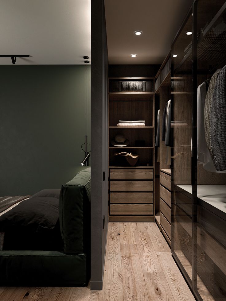 a walk in closet with wooden flooring and black furniture