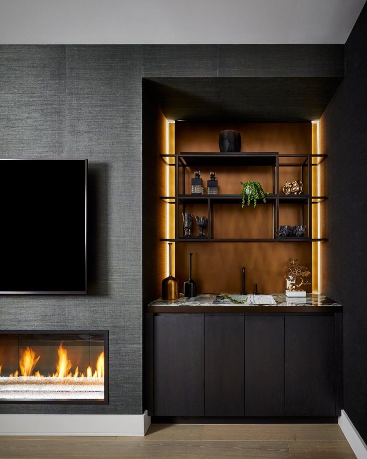 a living room with a fireplace and entertainment center in the corner, along with a flat screen tv mounted on the wall