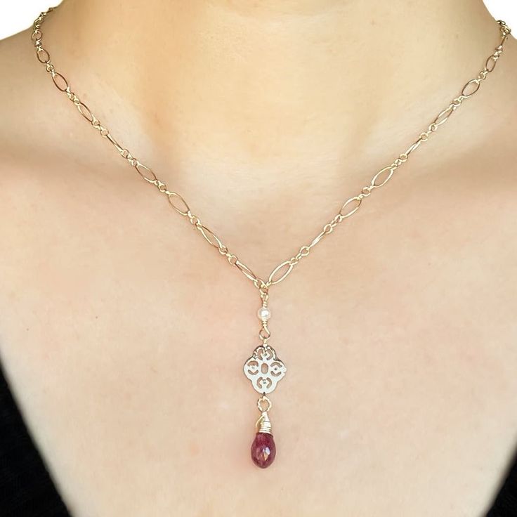 The ruby is probably the most well-known gemstone in the world, and its name will forever be linked with its striking red color. No other gemstone shares such a strong link with feelings of love and passion. Ruby is the birthstone for July and the gem for the 15th and 40th anniversaries. This necklace is in a classic style, incredibly elegant and refined. A ruby briolette stone dangles from a gold filigree; three tiny freshwater seed pearls are wire wrapped to the chain to add more dimension and detail to this beautiful piece of jewelry. MATERIALGold filled chain and componentsGenuine white freshwater seed pearlsGenuine ruby briolette gemstone SIZE10mm ruby briolette3mm pearls18-inch chain CLOSURELobster clasp WHAT IS GOLD FILLED?We used to have just 2 choices: pure gold or gold plated. Th Elegant Ruby Briolette Necklace, Elegant Ruby Gemstone Necklace, Elegant Ruby Birthstone Necklace In Gold, Fine Jewelry Ruby Necklace For Valentine's Day, Elegant Gold Ruby Birthstone Necklace, Classic Red Ruby Jewelry, Ruby Birthstone Necklace For Valentine's Day, Valentine's Day Ruby Birthstone Jewelry, Valentine's Day Ruby Birthstone Necklace