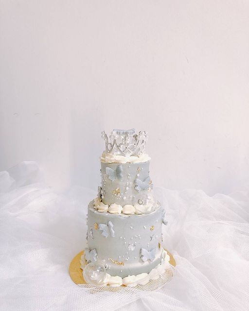 a three tiered wedding cake with a crown on top